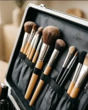 Brochas de maquillaje profesional organizadas en un compartimento de maleta con elásticos