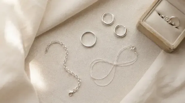 Colección de joyas de plata 925 sobre una superficie clara: anillo, pendientes y cadena