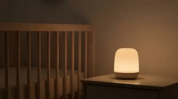 Luz nocturna recargable junto a una cuna durante una toma nocturna