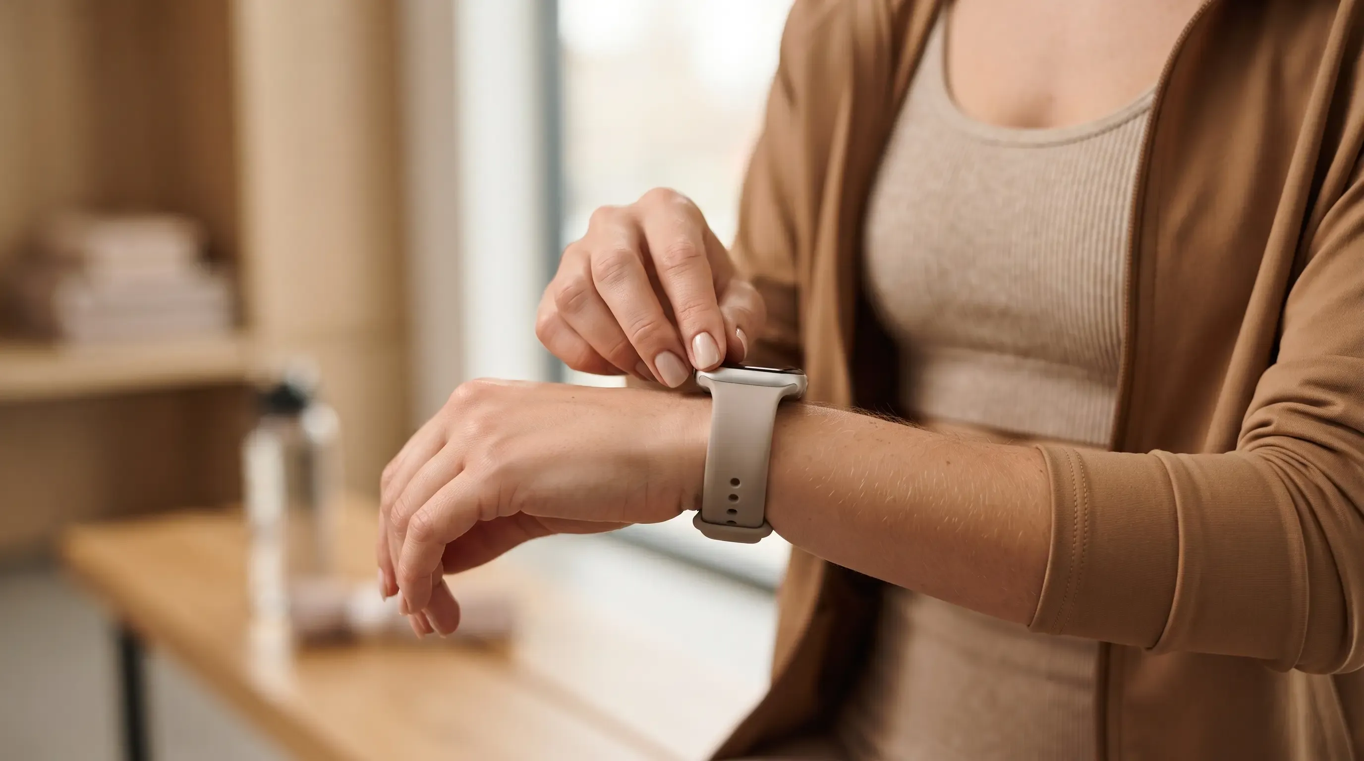 Mujer ajustando la correa de su smartwatch antes de entrenar