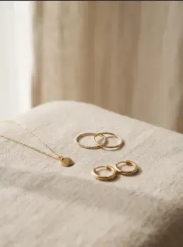 Joyas de vermeil de plata 925 con acabado dorado sobre fondo neutro